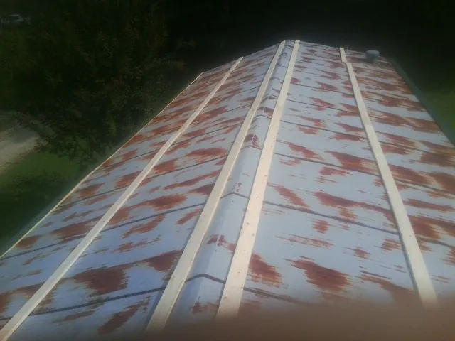 Rusted metal roof panels with new wood purlins before replacement — Storm Damage Roof Repair in Irondale by Roofing Brothers