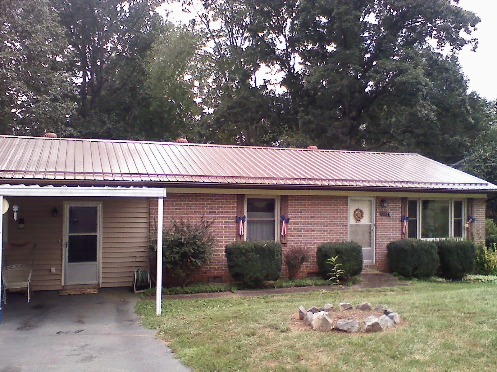 Bronze metal roof and carport on a brick ranch home — Roof Repair work by our crew in Irondale